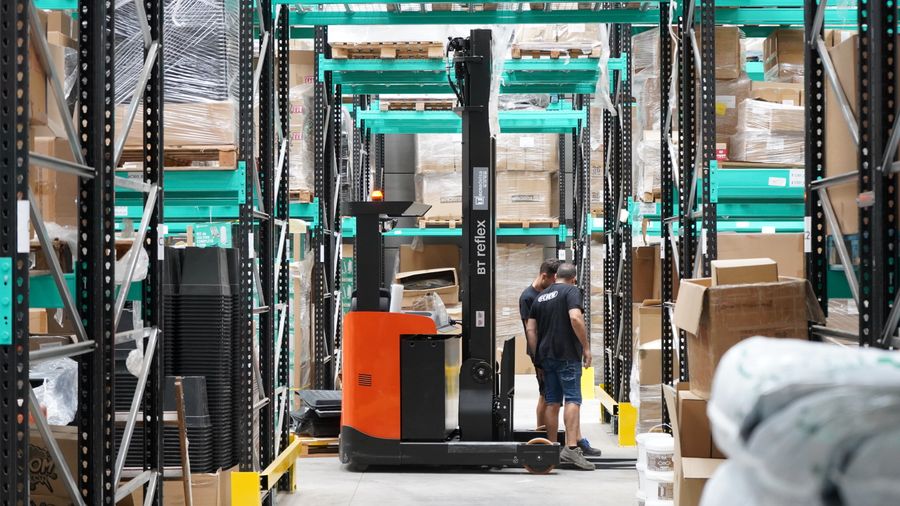 Warehouse team working beside material-handling equipment